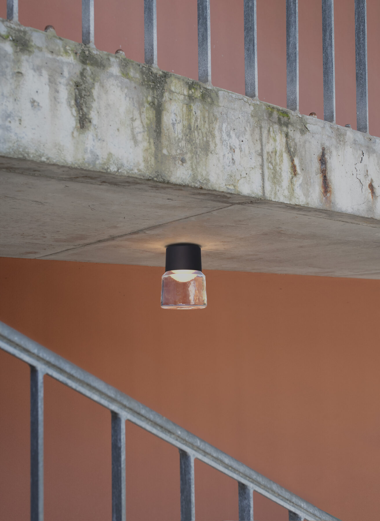 Die handgefertigte Gussglas-Leuchte CAST M mit schwarzem Aluminiumaufbau als Außenbeleuchtung im modernen Treppenhaus.